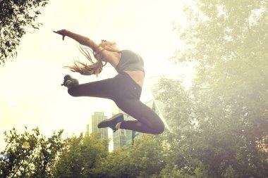 Fit atletik kadın koşucu açık havada büyük bir sıçrama performans