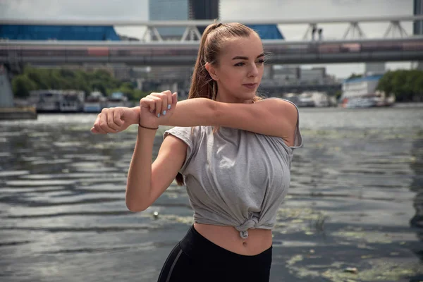 genç kadın büyük bir şehrin sokakta bir egzersiz yapar. güzel atletik kız