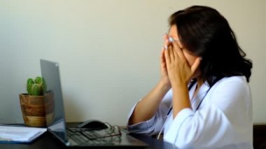 Hastanede masada oturan ve dizüstü bilgisayarda yazarak bilinmeyen kadın doktor yakın. Genç Kadın Doktor Hemşire Hastane Kliniği Nde.