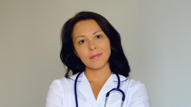 카메라를 보고 아름 다운 젊은 여자 레이디 닥터의 슬로우 모션 클로즈업. 직업, 의학 및 의료, 의학 교육의 개념. — 비디오