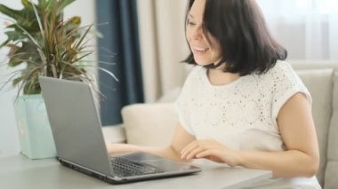 yavaş çekim. Kendine güvenen İş Kadını Modern Ofisinde Dizüstü Bilgisayar Üzerinde Çalışıyor. Şık Güzel Kadın Önemli İş Yapıyor. Pencerede Big City İş Bölgesi Görünümü