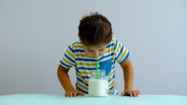 yavaş hareket asya Sevimli küçük çocuk mutfakta süt içme. neşeli çocuk milkshake içmek için seviyor