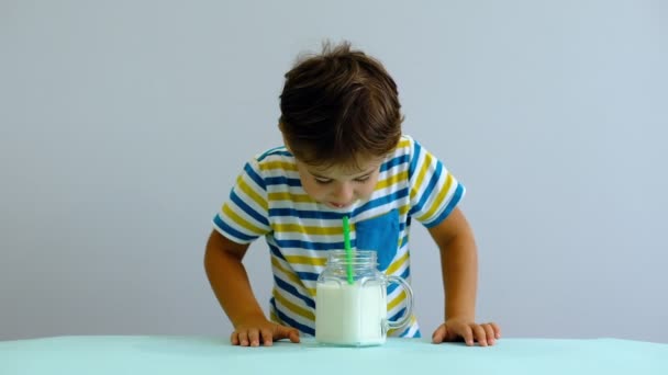 Slow motion asiático bonito menino bebendo leite na cozinha. menino alegre gosta de beber milkshake — Vídeo de Stock