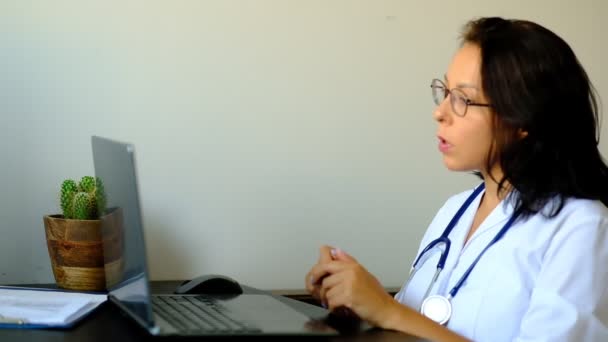 Primer plano de la doctora desconocida sentada en la mesa en el hospital y escribiendo en la computadora portátil. Enfermera doctora joven en la oficina de la clínica del hospital . — Vídeo de stock