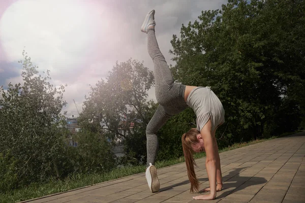 Young sporty attractive woman practicing yoga, doing Wild Thing, Flip-the-Dog exercise, Camatkarasana pose, working out, wearing sportswear, black pants and top, indoor full length — Stock Photo, Image