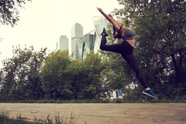 Otopark, garaj çatı üzerinde gün batımı sırasında çalışan atletik kadın