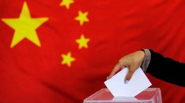 Hand holding ballot paper for election vote concept. elections, The hand of woman putting her vote in the ballot box. China Flag on background. clipart