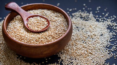Siyah bir arka plan üzerinde beyaz Quinoa tohumları. Kase quinoa ve mutfak masası üst görünümünde bir kaşık. Sağlıklı ve diyet superfood ürün.
