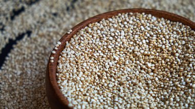 Siyah bir arka plan üzerinde beyaz Quinoa tohumları. Mutfak masası üst görünümünde kase quinoa. Sağlıklı ve diyet superfood ürün.