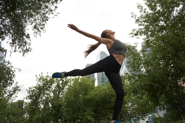 Chica deportiva de fitness en ropa deportiva de moda haciendo ejercicio de fitness en la calle. Bailarina de hip hop, deportes al aire libre . — Foto de Stock