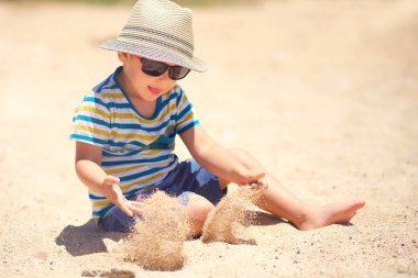 Tatil, küçük çocuk. Üç yaşında. Kumsalda kumu kazmak eğlenceli.