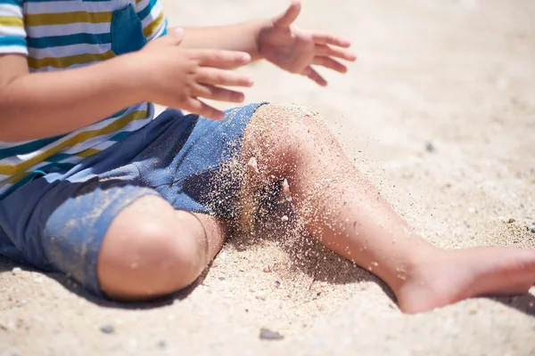 Feriado, menino três anos de idade divertido cavando na areia na praia . — Fotografia de Stock