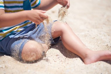 Tatil, küçük çocuk. Üç yaşında. Kumsalda kumu kazmak eğlenceli.