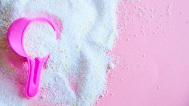 Çok renkli arka planda çamaşır tozu ile kepçeyi ölçmek