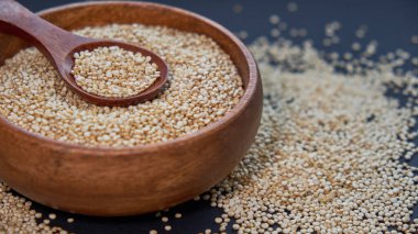 Siyah bir arka plan üzerinde beyaz Quinoa tohumları. Kase quinoa ve mutfak masası üst görünümünde bir kaşık. Sağlıklı ve diyet superfood ürün.