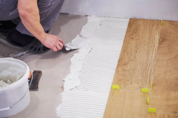 Primer plano del manitas colocando separador de azulejos. Colocando las baldosas. Mejora del hogar —  Fotos de Stock