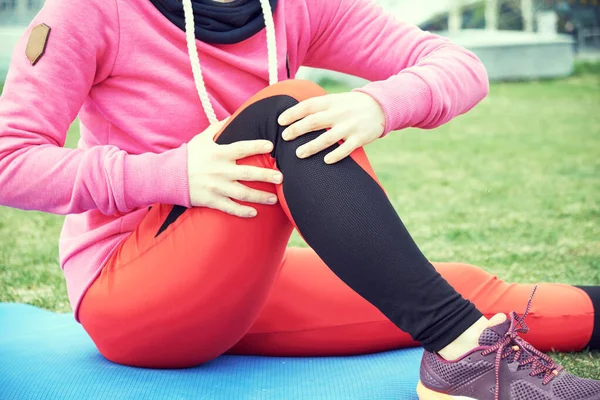 Спортивная травма колена бегуна. Женщина в боли во время бега по пляжу . — стоковое фото