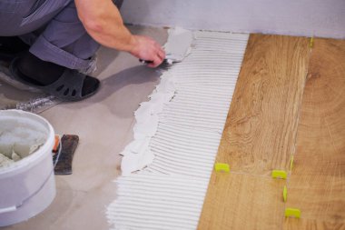 Kiremit uzayı yerleştiren tamirciye yakın plan. Döşemeleri yerleştiriyorum. Ev geliştirme