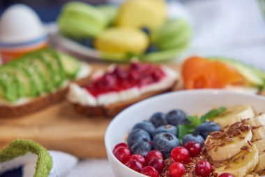 Kahvaltı üstü siyah arka plan. Böğürtlenli yulaf ezmesi, tahta tepside tost, fındık, kahve.