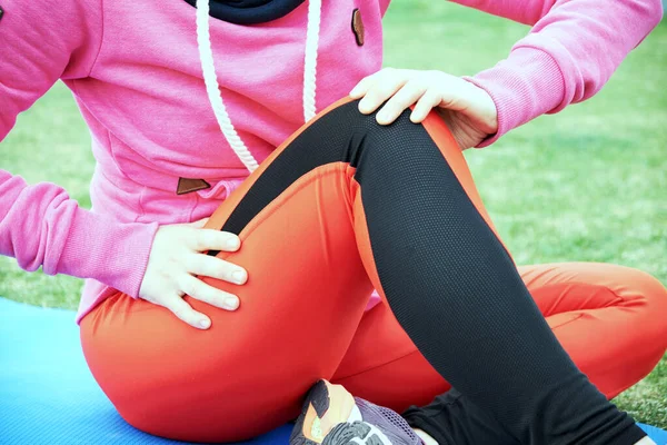 Atleta femenina que sufre una lesión de rodilla o rótula durante el entrenamiento al aire libre en el camino de tierra . — Foto de Stock