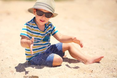 Tatil, küçük çocuk. Üç yaşında. Kumsalda kumu kazmak eğlenceli.