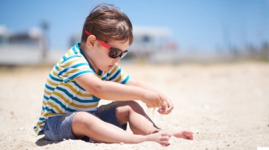 Tatil, küçük çocuk. Üç yaşında. Kumsalda kumu kazmak eğlenceli.
