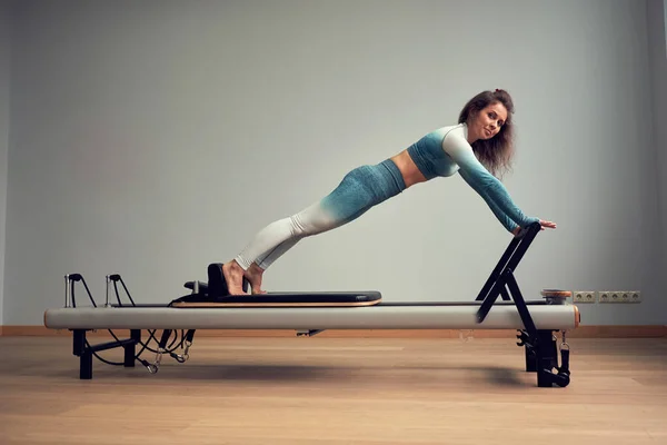 Allenamento con body pilates training. esercizi di riformatore pilates atletici. attrezzature per macchine pilates. giovane donna asiatica pilates stretching sport in riformatore letto instructor ragazza in un studio — Foto Stock