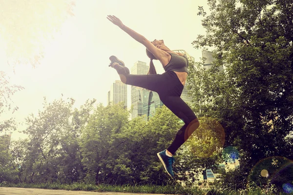 Ajuste atlética mujer corredor realizar un gran salto al aire libre — Foto de Stock