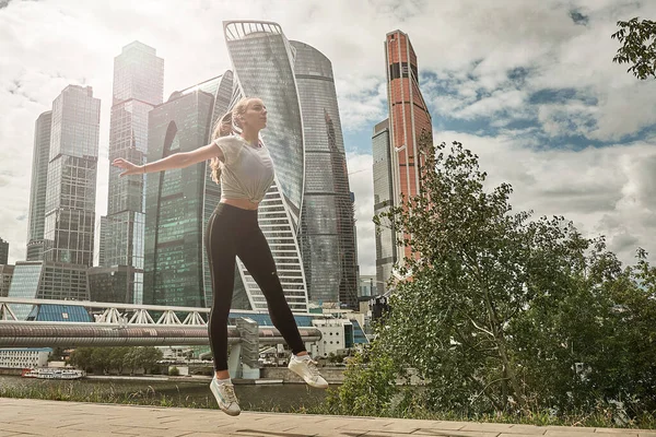 Fit athletic woman runner performing a big leap outdoors