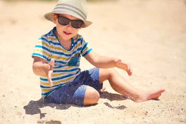 Feriado, menino três anos de idade divertido cavando na areia na praia — Fotografia de Stock