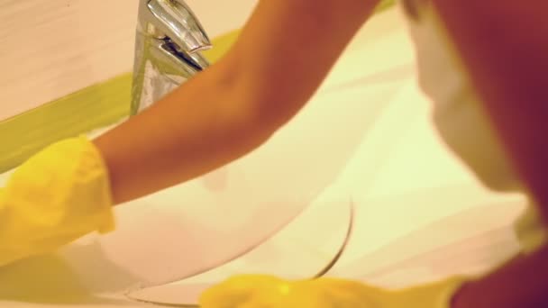 Slow motion. Woman doing chores in bathroom at home, cleaning sink and faucet with spray detergent. Cropped view — Stock Video