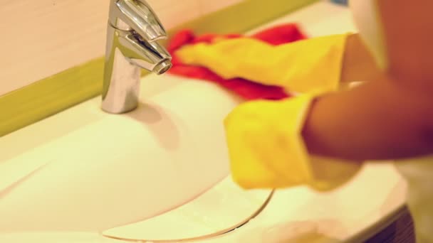 慢动作。女人在家里的浴室里做家务，用喷雾洗涤剂清洗水槽和水龙头。裁剪视图 — 图库视频影像