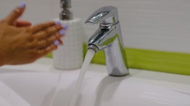 yavaş çekim. Banyoda sabunla ellerini yıkayan kadın