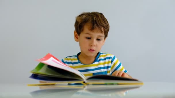 Cámara lenta asiático niño leyendo libro en sala de estar. Divertirse y emocionados o historias de libros interesados con la felicidad sonriendo, riendo cara . — Vídeo de stock