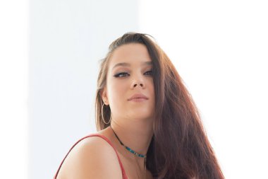 Siyah tişört giyen, kameraya bakan, erkek arkadaşıyla tartışan, stüdyo duvarında tek başına duran, güvensizlik ve hayal kırıklığıyla dolu ciddi, genç, melez bir kadının vesikalığı.