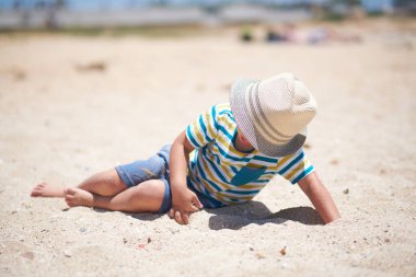 Tatil, küçük çocuk. Üç yaşında. Kumsalda kumu kazmak eğlenceli.