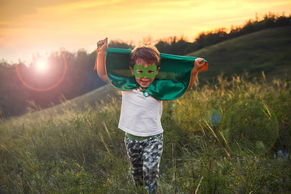 Un ragazzino che fa il supereroe. Ragazzo in costume da supereroe. bambino felice corre incontro al fotografo . — Foto Stock