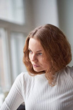 Güzel kıvırcık bir kızın portresi. Penceredeki gizemli yüz..