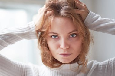 Güzel kıvırcık bir kızın portresi. Penceredeki gizemli yüz..