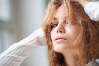 Güzel kıvırcık bir kızın portresi. Penceredeki gizemli yüz..