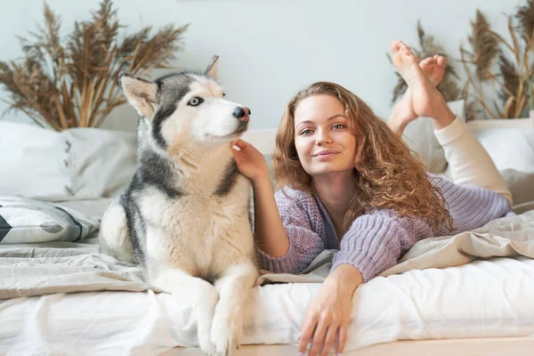 赤毛女性リラックスに家で彼女のペット犬ハスキー — ストック写真