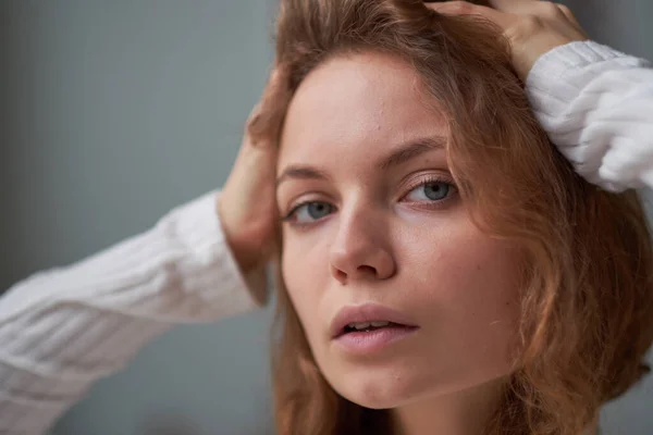 Porträt eines schönen lockigen Mädchens. das geheimnisvolle Gesicht einer Frau am Fenster. — Stockfoto