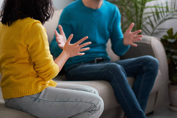 грустная жена и муж, злая пара в спальне. Несчастная парочка. Муж и жена сидят на диване и эмоционально разговаривают.
.