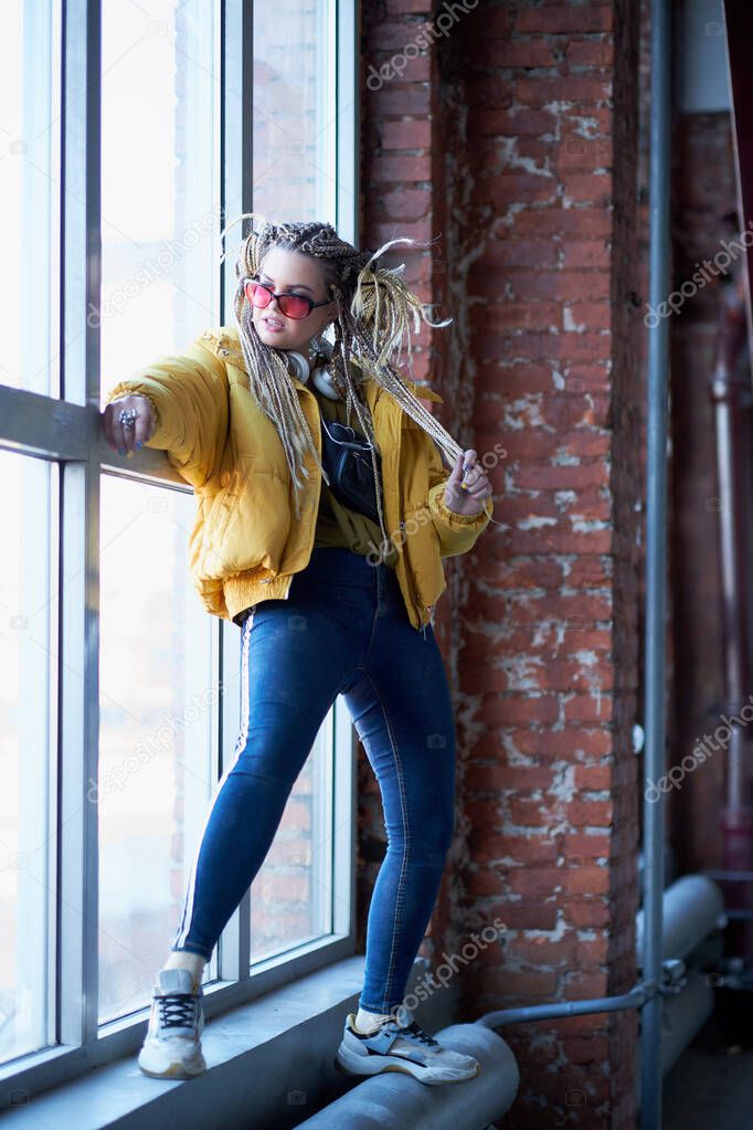 portrait of an eccentric modern young woman, bright make-up sunglasses, and a crazy hairstyle. cocky teen millennial