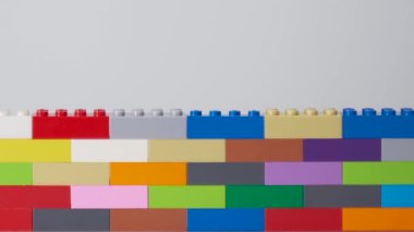 Plastik yapı taşı. Plastik tuğla duvar. Plastik yapı taşlarının duvarı izole edilmiş. Tebrik kartı ve tatiller için uygun. Beyaz arka plan. Stok görüntüleri. Videoyu kapat.