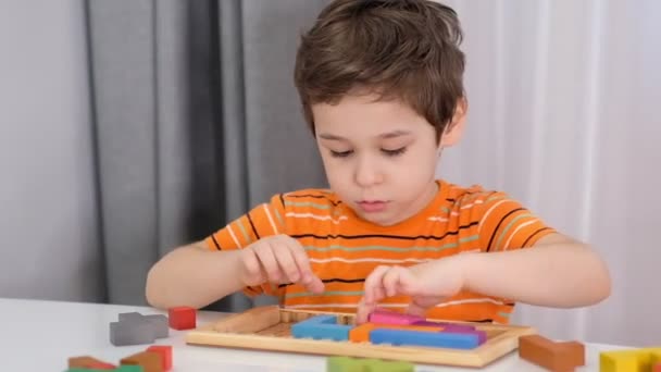 Primer plano de manos de niños jugando con ladrillos de madera de colores en la mesa. material de archivo. Vídeo en cámara lenta. De cerca. — Vídeo de stock