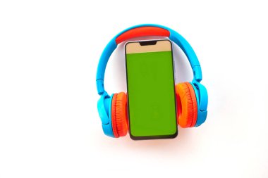Beyaz arka planda boş ekran ve kulaklıklı akıllı telefon. Müzik ve teknoloji konseptinin en üst noktası. Kulaklıklı, düz akıllı telefon. Yaratıcı tasarım metni ve sözcük için kopyalama alanı.