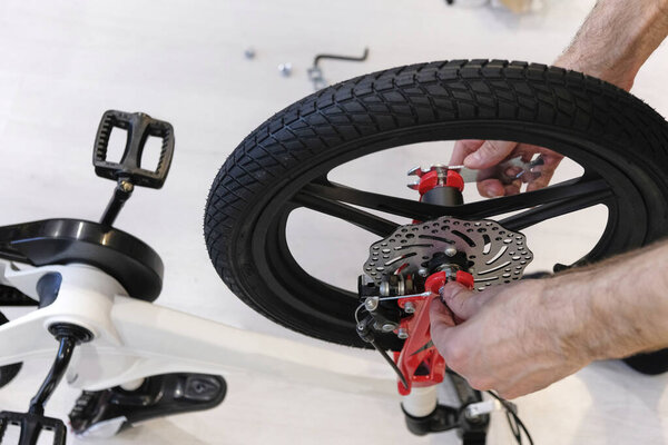 man assembling new bicycle to learn to ride. disc wheels. inflatable tires