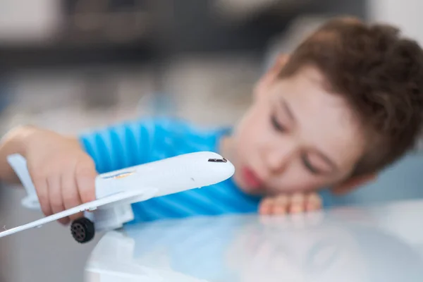 Little asian boy is playing with toy plastic airplane. — Stock Photo, Image