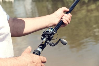 Nehirde balık avlıyorum. Nehir kıyısında elinde olta olan bir balıkçı. İnsan balıkçı bir balık yakalar. Balıkçılık, dönen makaralar, balıklar, Breg nehirleri. Kırsal kaçamak konsepti. Balıkçılık hakkında makale.